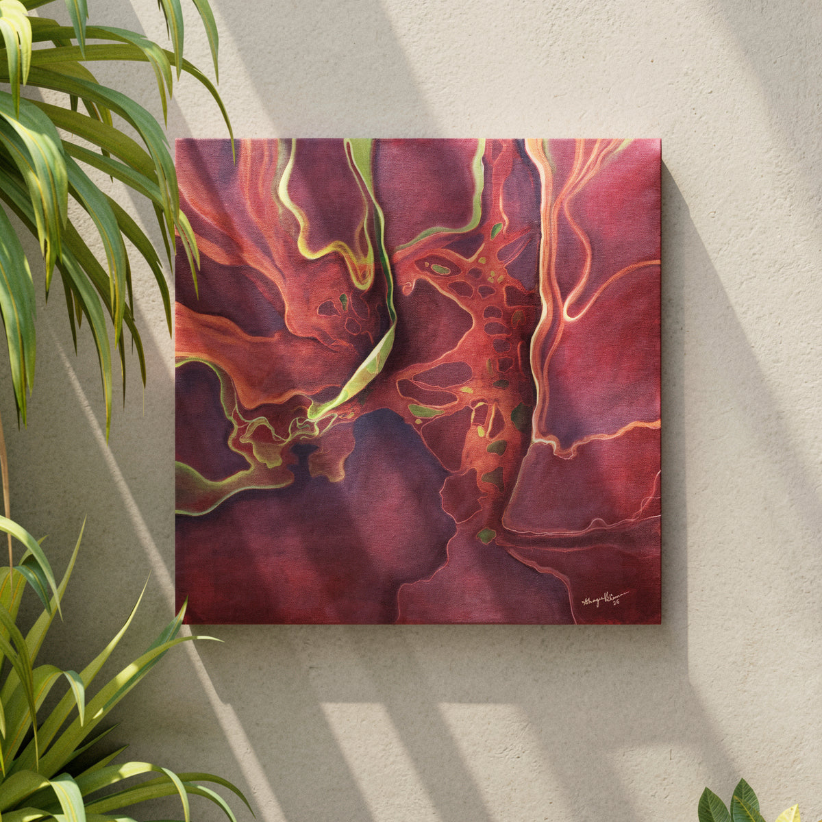 Abstract canvas wall art featuring swirling marbled patterns in deep burgundy, red, and purple with bright yellow-green veining, displayed on a light beige wall with green plant leaves framing the scene.
